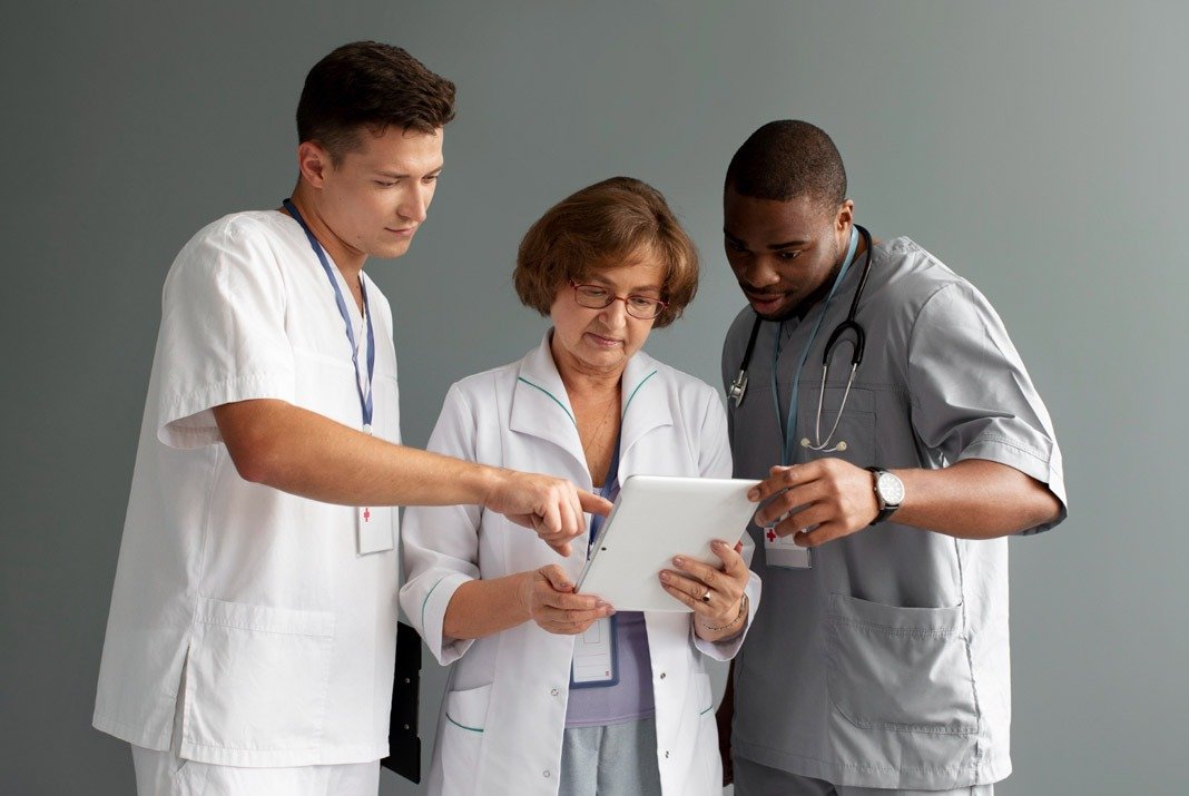 Medical professionals collaborating on a digital tablet – multidisciplinary cancer care team at CurePoint Cancer Center.